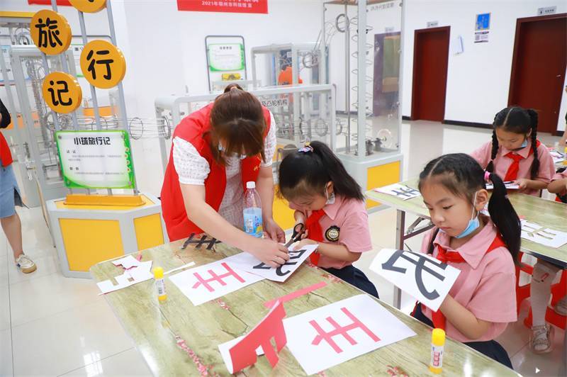 2021年7月10日，鄂州市科協(xié)組織落駕坪小學(xué)學(xué)生在鄂州市科技館開展社會主義核心價值觀系列活動，圖為開展的紅色剪影圓夢中華剪紙活動，志愿者指導(dǎo)同學(xué)們.jpg
