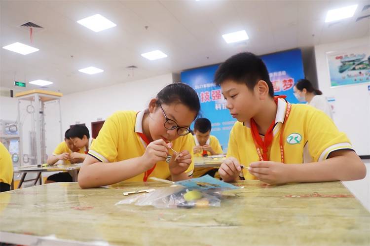 2021年7月9日鄂州市科協(xié)組織新民街小學(xué)學(xué)生在鄂州市科技館開展社會主義核心價值觀系列活動，圖為開展的科技創(chuàng)新圓夢中華科技小制作活動，孩子們正在相互配合制作蠕蟲機器人.jpg