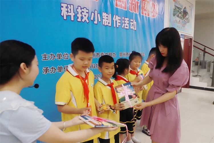 2021年7月9日鄂州市科協(xié)組織新民街小學(xué)學(xué)生在鄂州市科技館開展社會主義核心價值觀系列活動，圖為開展的科技創(chuàng)新圓夢中華科技小制作活動，科協(xié)王雨濛部長正在為優(yōu)先制作完成的學(xué)生頒發(fā)獎品.jpg